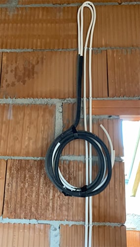 Instalacja przewodu elektrycznego zabezpieczonego przez peszel, który wejdzie do sufitu podwieszanego